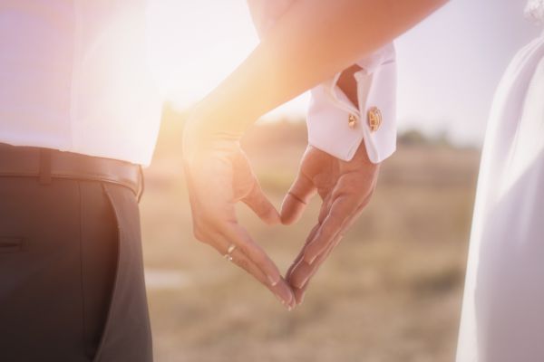 picture of a man and woman's hand making the shape of a heart