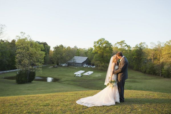 bride and groom kissing on a hill