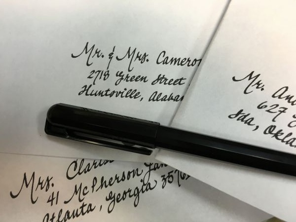 An image of white invitation envelopes with calligraphy 