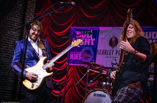 view of paradise bar and grill from sound with umbrellas and people on waterfront