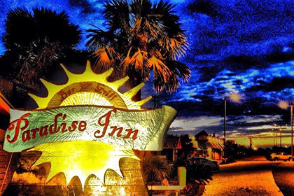Paradise Inn sign brightly lit at night
